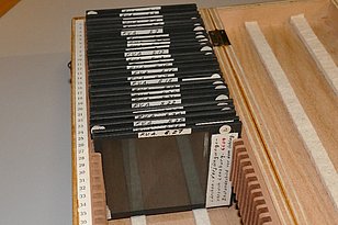 A wooden box containing glass slides measuring 8.5 x 10 cm.