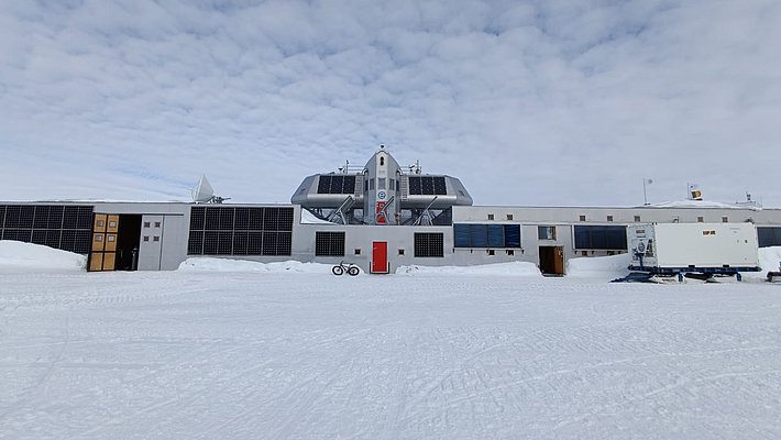 Fassade einer Basis im Schnee, bedeckt mit zahlreichen schwarzen Sonnenkollektoren