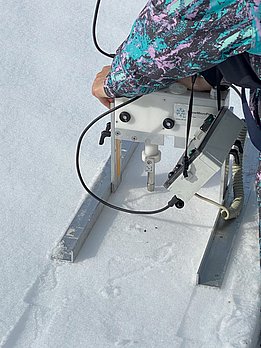 Person führt SMP-Messung mit SnowMicroPen auf Schneeoberfläche durch