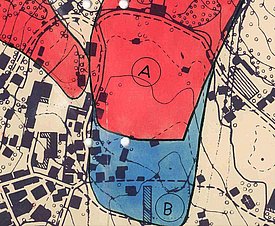 Kartenausschnitt mit zwei farblich markierten Gefahrenzonen A in Rot und B in Blau, umgeben von Gebäuden und topografischen Linien