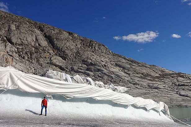 Unter der Gletscherabdeckung am Rhonegletscher ist in einem Jahr rund 4 Meter weniger Eis geschmolzen als im nicht abgedeckten Bereich im Vordergrund. (Foto: Matthias Huss)