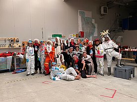 Eine Gruppe Menschen posiert in selbstgemachten Kostümen.