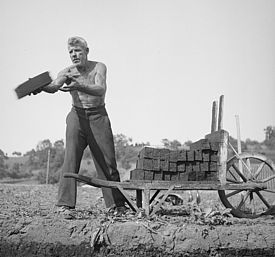 Torfabbau im Inser Moos während des Zweiten Weltkriegs: Ein Arbeiter stapelt die exakt gestochenen Turben auf eine «Turbebäre» (Schubkarre), um diese anschliessend zum Trocknungsplatz zu schieben. 