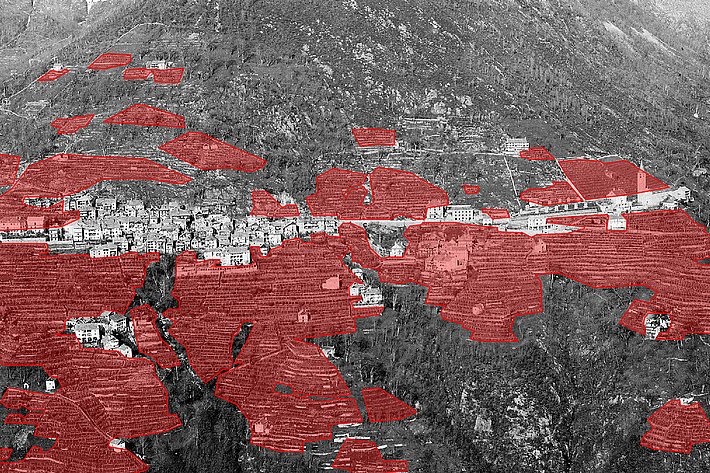 Schwarz-weiß-Luftaufnahme von Loco im 1885 mit in rot markierten Weinbergen rund um das Dorf im Tal