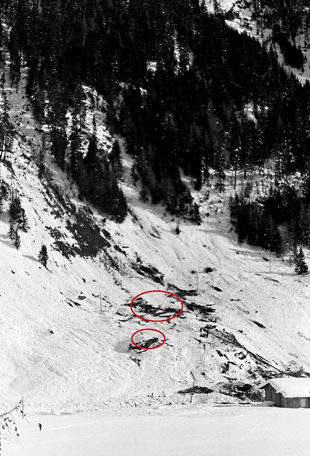 Pente de montagne enneigée avec traces d'avalanche et deux zones cerclées en rouge