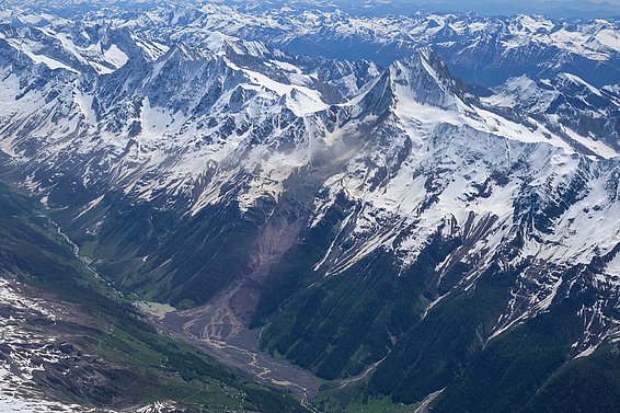 Das Bild zeigt eine Luftaufnahme vom Fels- und Eissturz in Blatten mit schneebedeckten Gipfeln. 