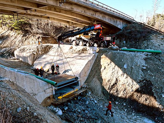 Zentimetergenauer Einbau der über 7 Tonnen schweren Stahlkonstruktion in die Aussparung der aus Beton gefertigten Wildbachsperre unter der Kantonsstrassenbrücke über den Illgraben. (Bild: Brian McArdell, WSL)