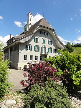 Ein großes Gebäude mit einem markanten Dach, das die Architektur der Umgebung prägt.  