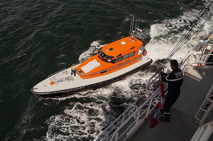 Ein Leitboot zeit den Weg in den Hafen.