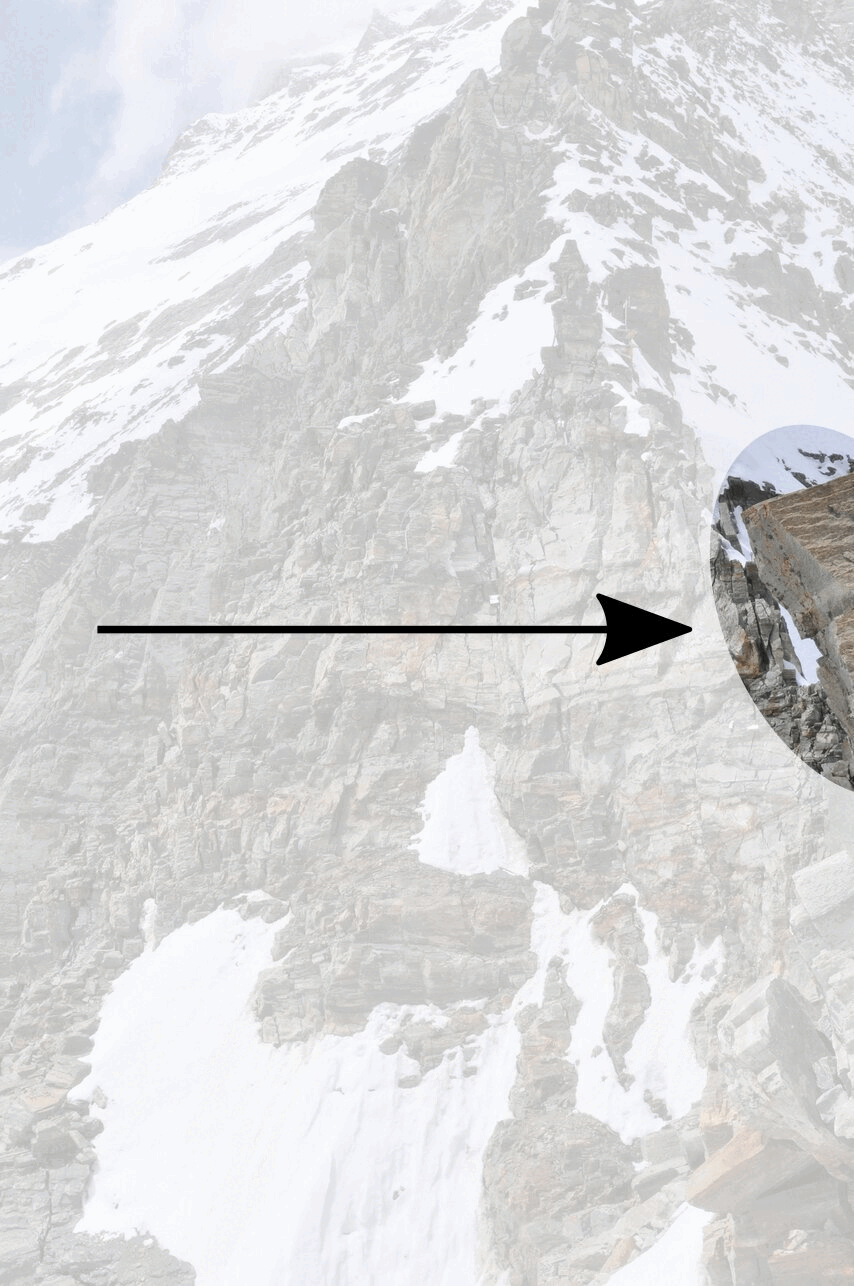 Ein Berg mit schneebedeckten Felsen. Ein Pfeil zeigt auf einen Bereich, wo ein großer Felsblock abbricht.